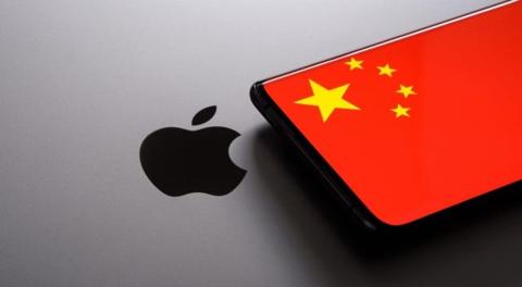 من iPhoneIslam.com، هاتف ذكي مزود بحافظة بتصميم العلم الصيني موضوعة فوق سطح ويظهر عليه شعار Apple.