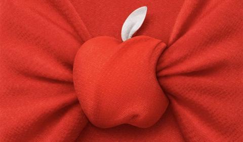 من iPhoneIslam.com، تم تثبيت قماش أحمر في المنتصف، مما يخلق شكل تفاحة مع ورقة قماش بيضاء في الأعلى، يشبه إلى حد كبير حدثًا غير متوقع من أخبار الأسبوع.