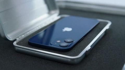 من iPhoneIslam.com، تخلصت من هاتف iPhone الأزرق الموجود في علبة على الطاولة.