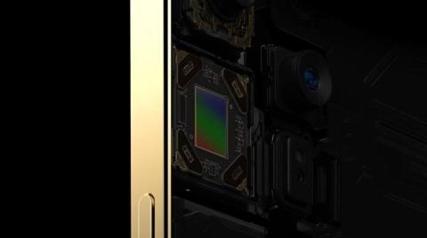من iPhoneIslam.com، عرض عن قرب لجهاز ذو حافة ذهبية، يكشف عن المكونات الداخلية بما في ذلك العديد من الكاميرات والدوائر، مما يجعله مثاليًا للعرض أثناء أخبار الهامش.