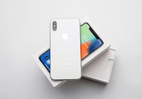 من iPhoneIslam.com، جهاز iPhone X أبيض اللون موضوع فوق صندوق، ويقدم نصائح مهمة من Apple قبل شراء جهاز مستعمل.