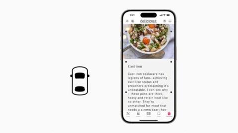 من iPhoneIslam.com، هاتف ذكي يعرض مقالًا عن وصفة طعام بجانب أيقونة بسيطة لسيارة على خلفية بيضاء، تذكرنا بالعروض التقديمية الأنيقة التي شوهدت في مؤتمر WWDC 2024.