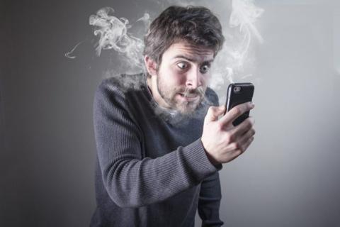 من iPhoneIslam.com، رجل يستمتع بهاتفه الخلوي ويخرج منه الدخان.